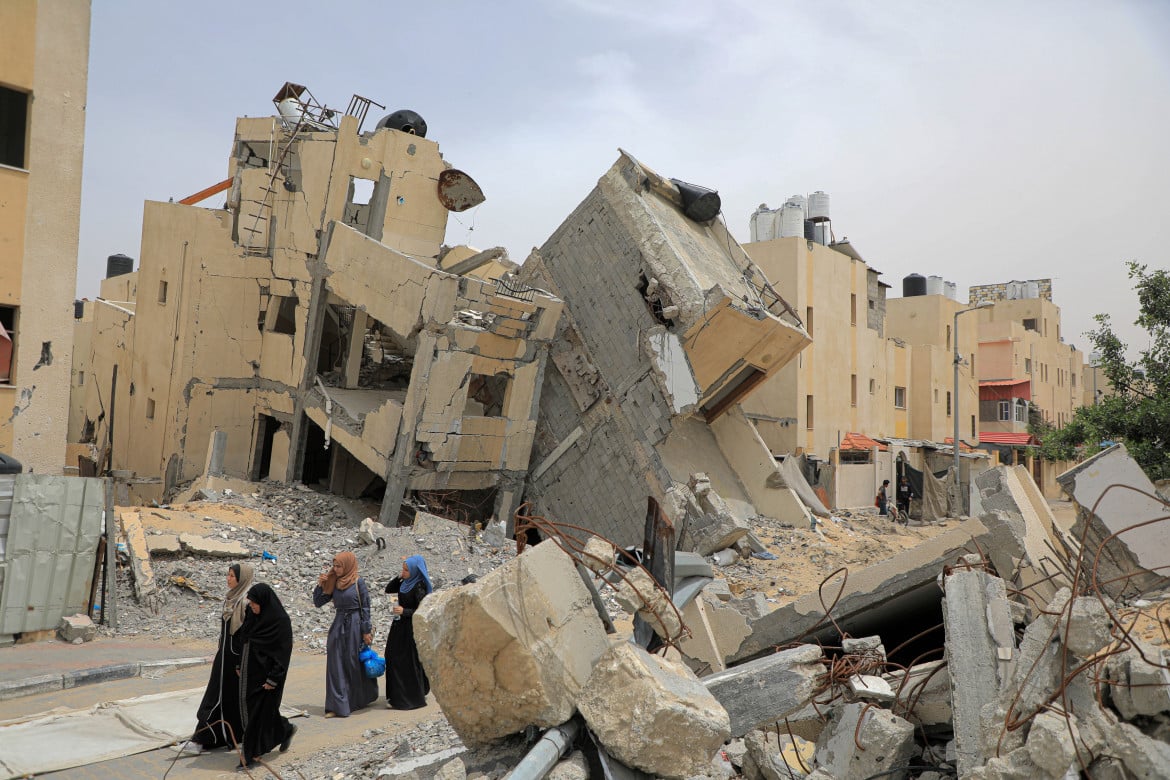 Palestinesi tra i palazzi distrutti a Rafah